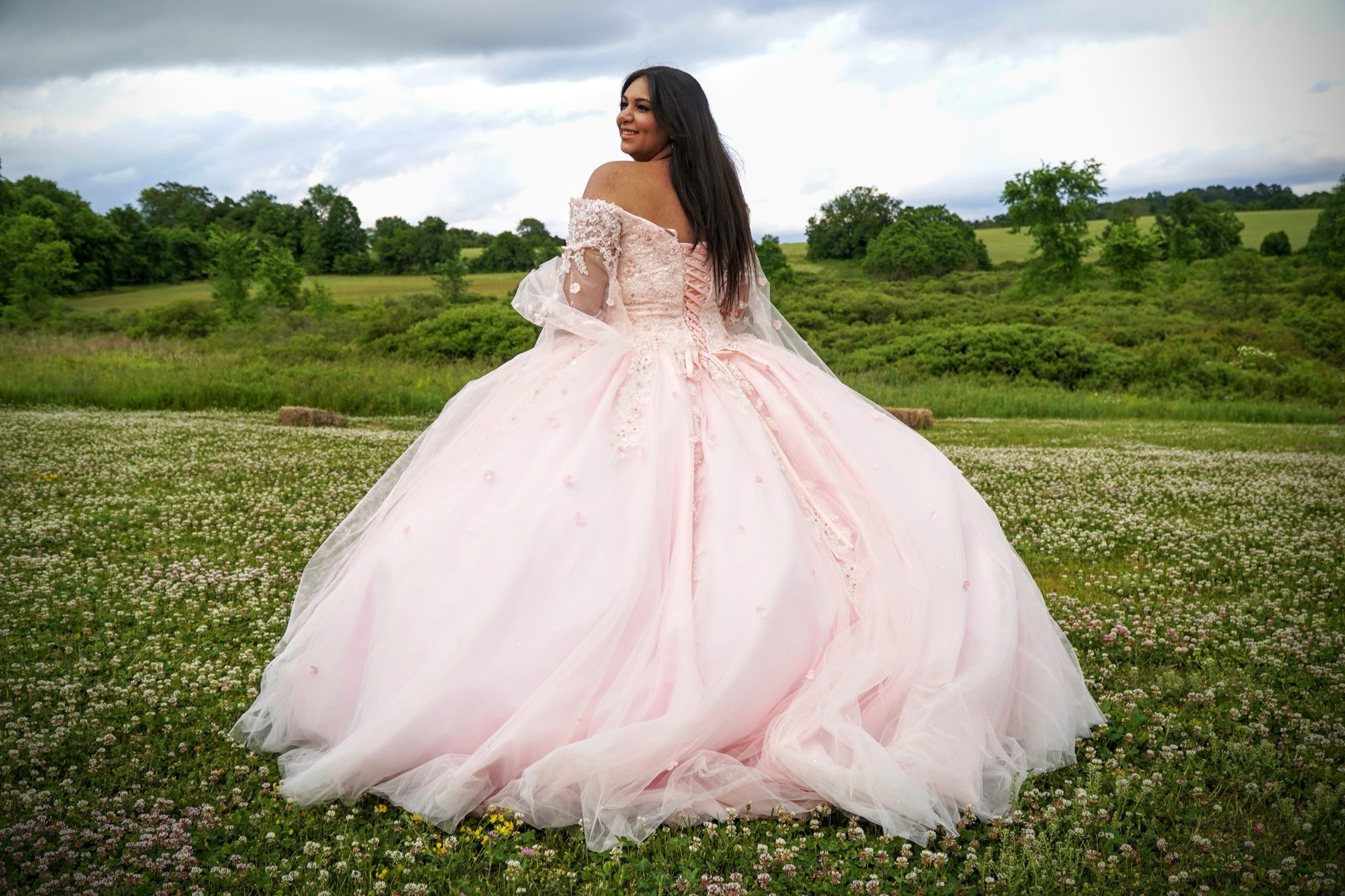 Young woman in a pink gown in an open field, photographed by Stella Magloire