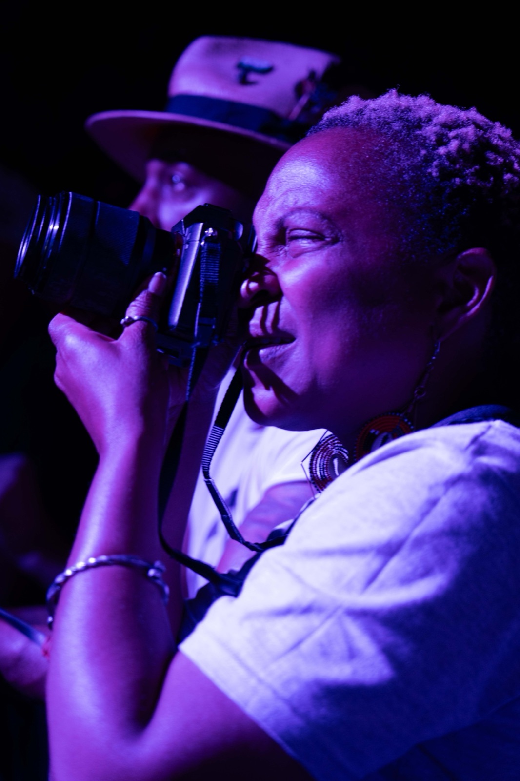 Stella Magloire shooting with her camera under purple stage light